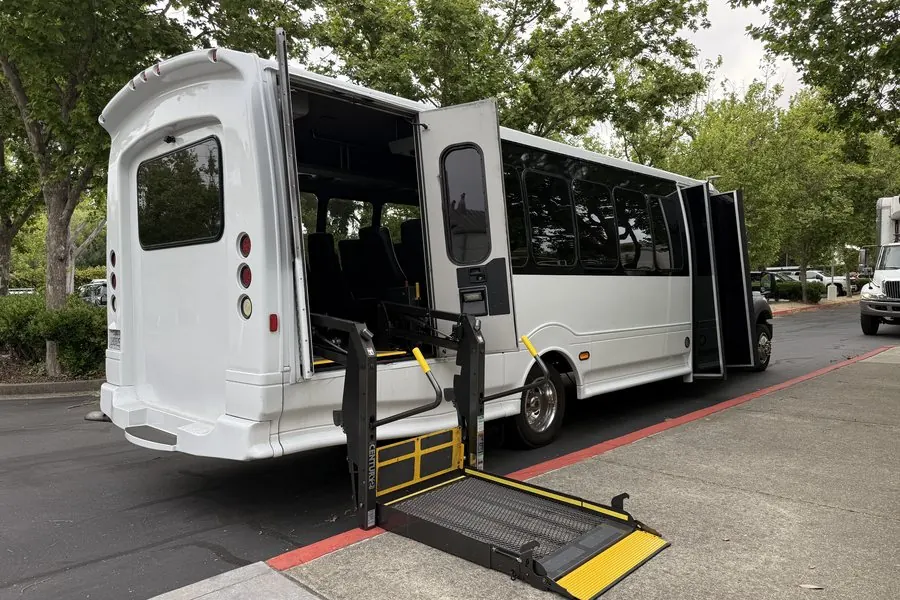 White Umbrella minibus with its wheelchair lift platform lowered to the kerb